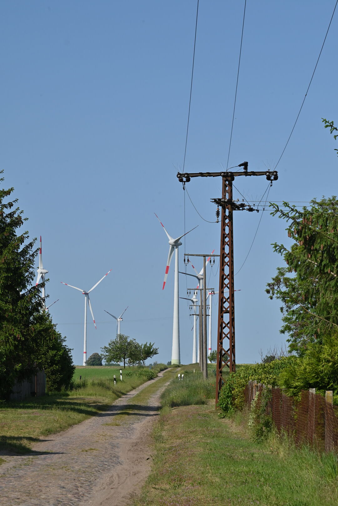 Windpark mit verrostetem Strommast